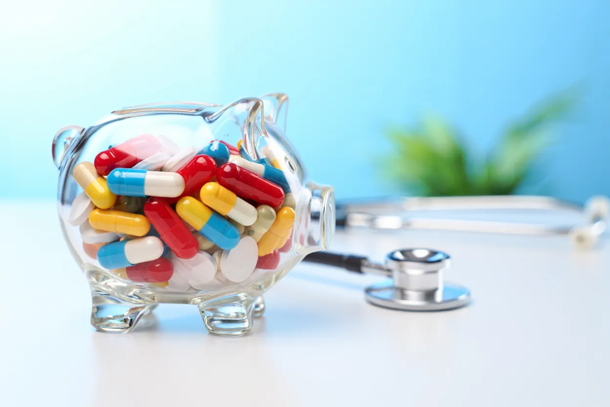 Tirelire transparente remplie de gélules sur un bureau médical, concept d'économies de santé