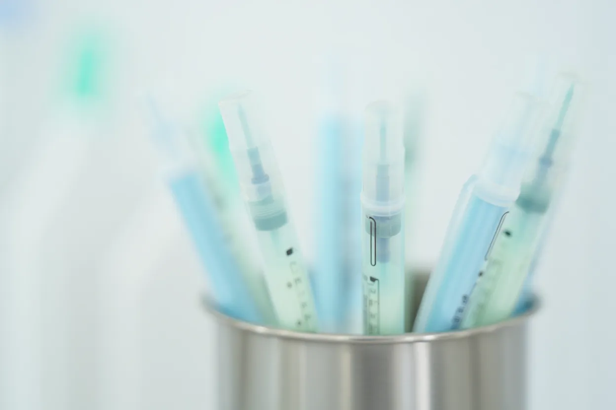 Stylos injecteurs de différentes couleurs alignés sur un plateau médical, concept de pharmacovigilance GLP-1